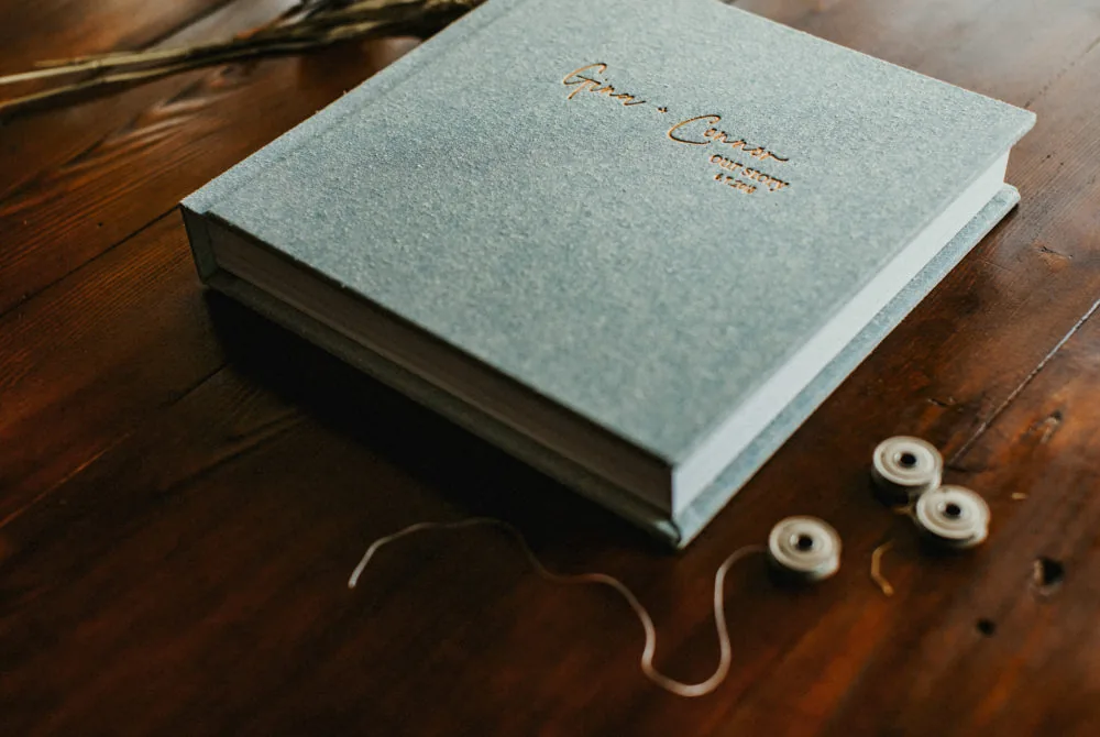 Blue linen wedding album with the couple's names engraved on the cover