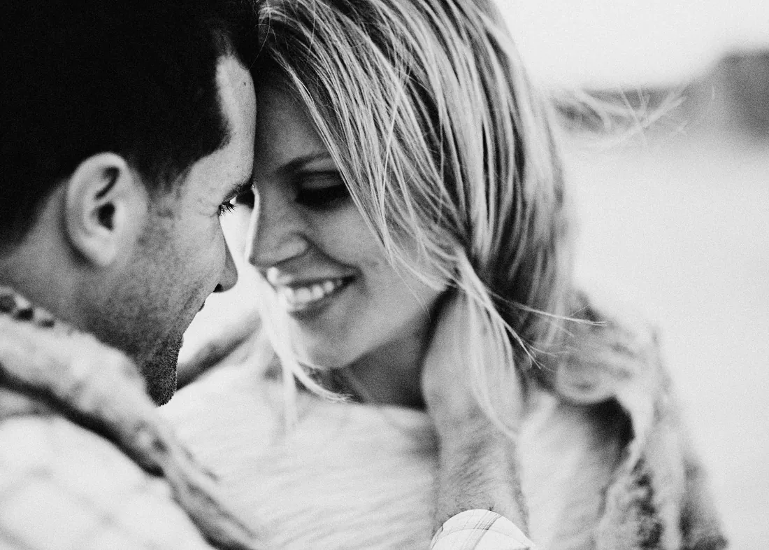 Black and white close-up of an engaged couple smiling