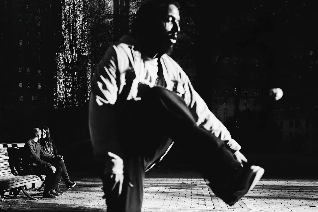 Black and white photo of an engaged couple dancing in dramatic light