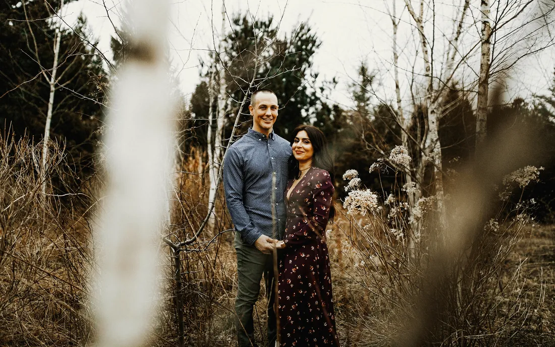 Engaged couple in tall winter grass