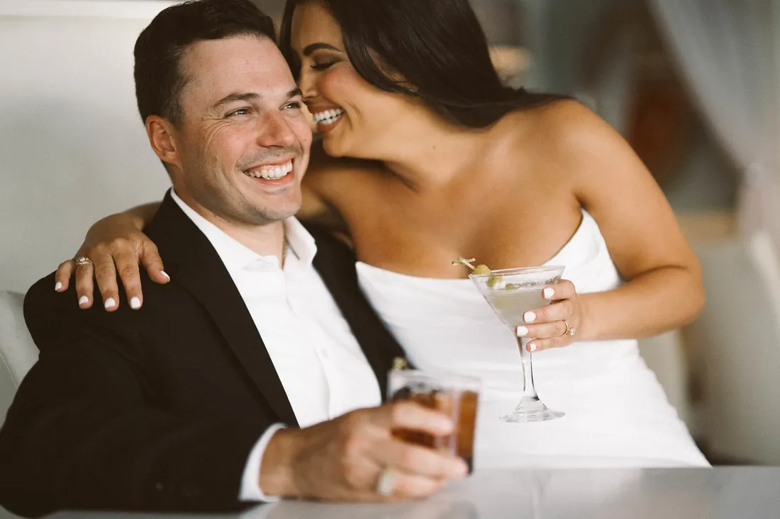 Engaged couple laughing together over drinks at Congress Hall in Cape May, NJ