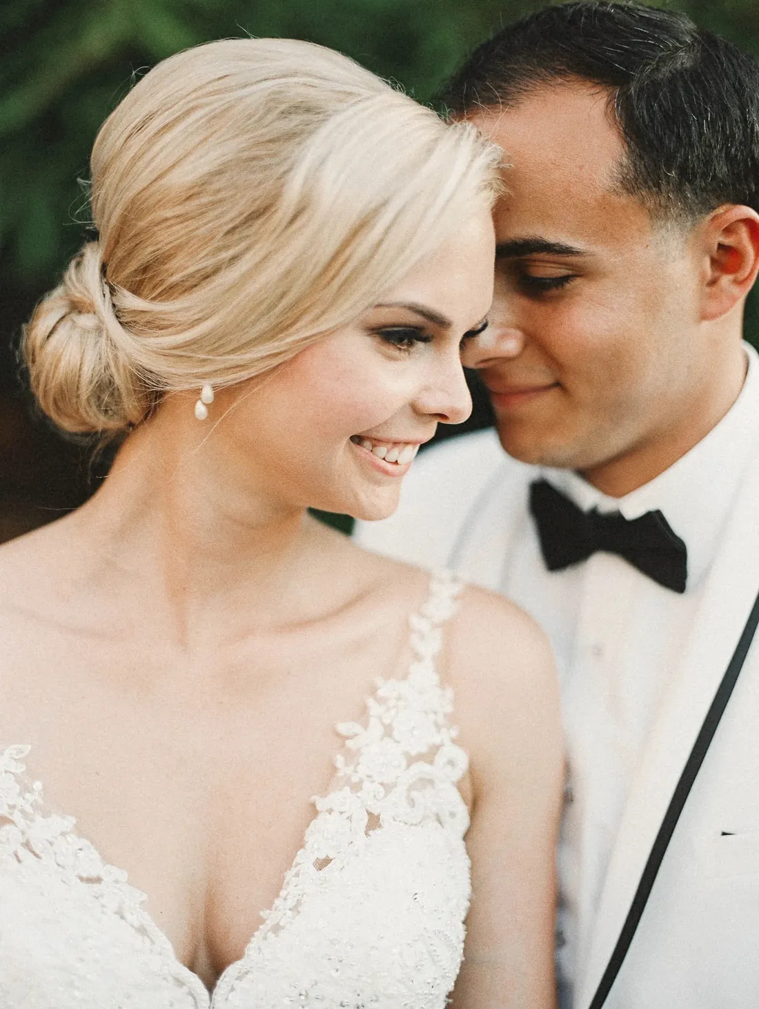 Film portrait of a smiling bride and groom cheek to cheek