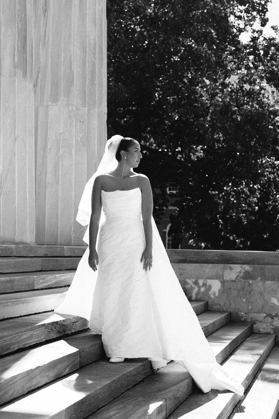 Black and white photo of a bride on stone steps