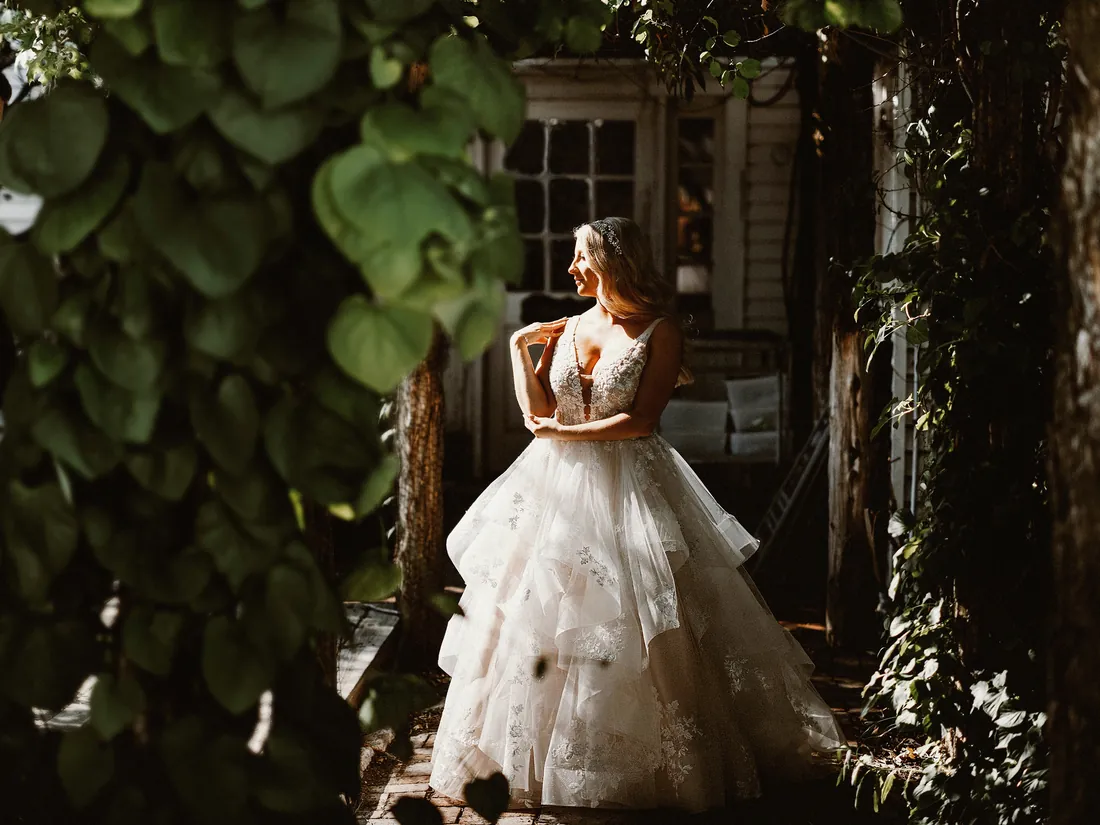 Bride in a layered gown framed by ivy