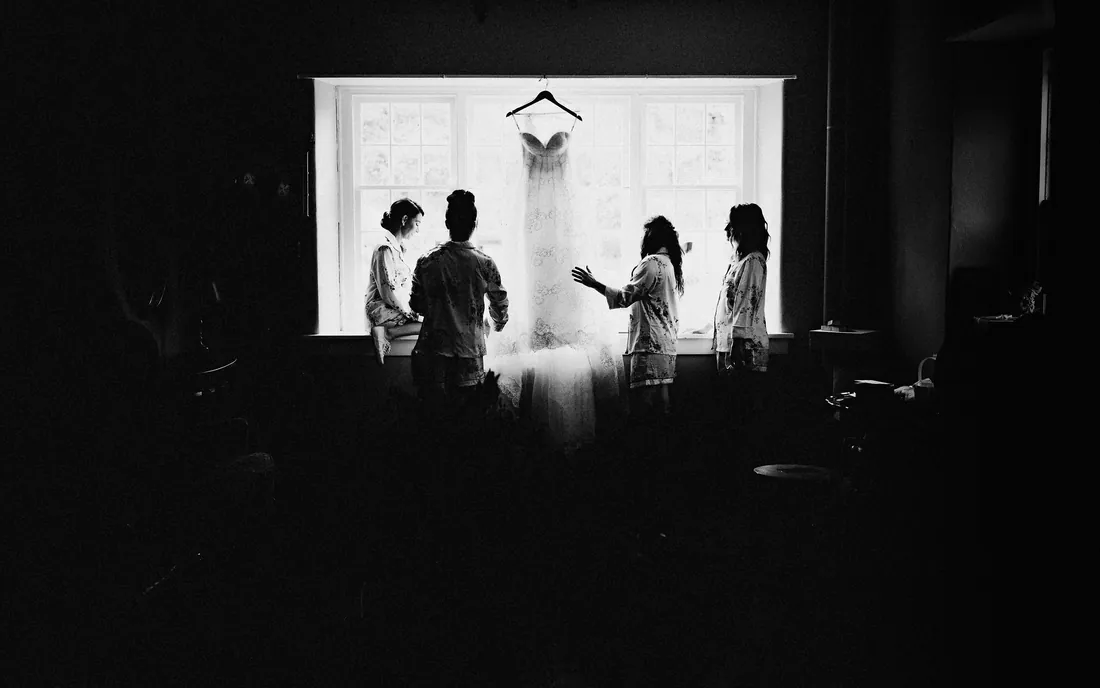 Bride and bridesmaids silhouetted by a bright window