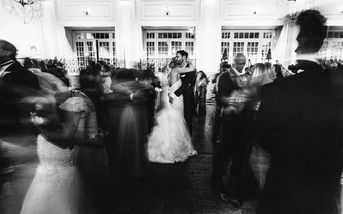 Black and white photo of a first dance with guests in motion