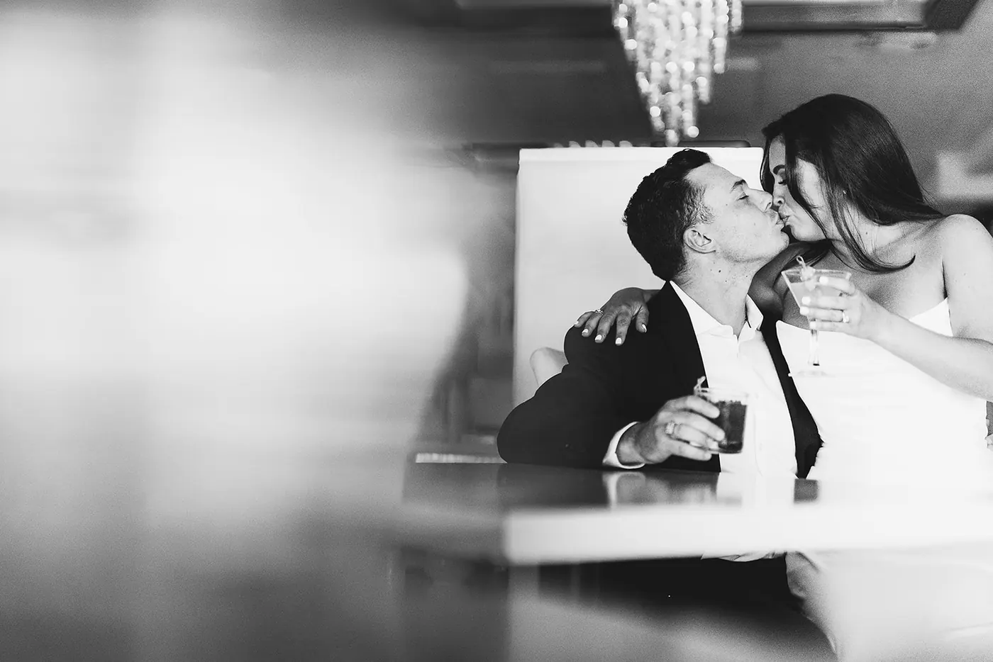 Black and white photo of Celeste kissing Branon at the table