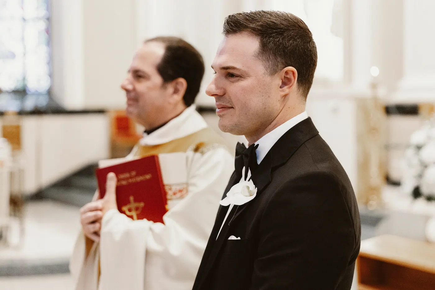 Branon smiling as he waits at the altar during their ceremony at Saint Monica Roman Catholic Church in South Philadelphia