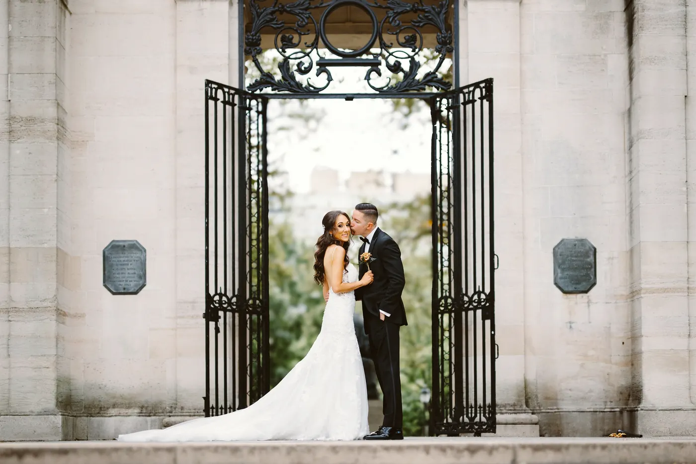 Chris and Danielle kissing in front of the ornate iron gates at the Rodin Museum in Philadelphia