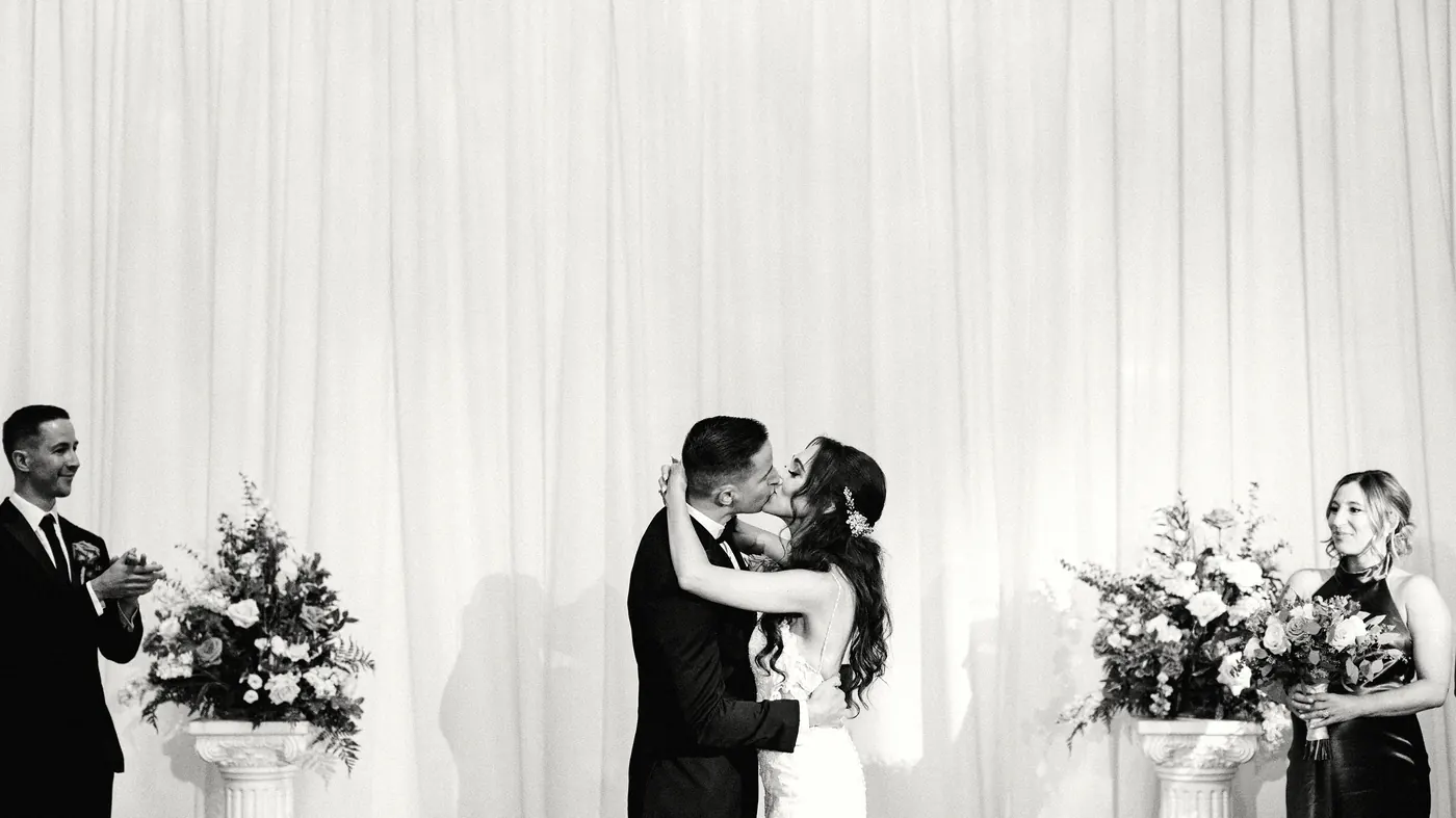 Black and white photo of Chris and Danielle's first kiss at Cescaphe Ballroom at the Ben in Philadelphia