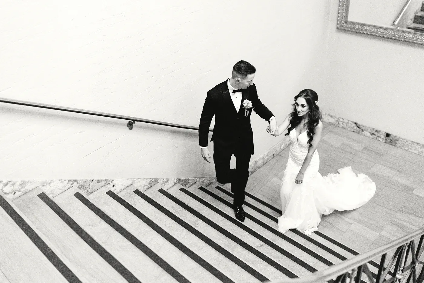 Black and white photo of Chris leading Danielle up the stairs at Cescaphe Ballroom at the Ben in Philadelphia
