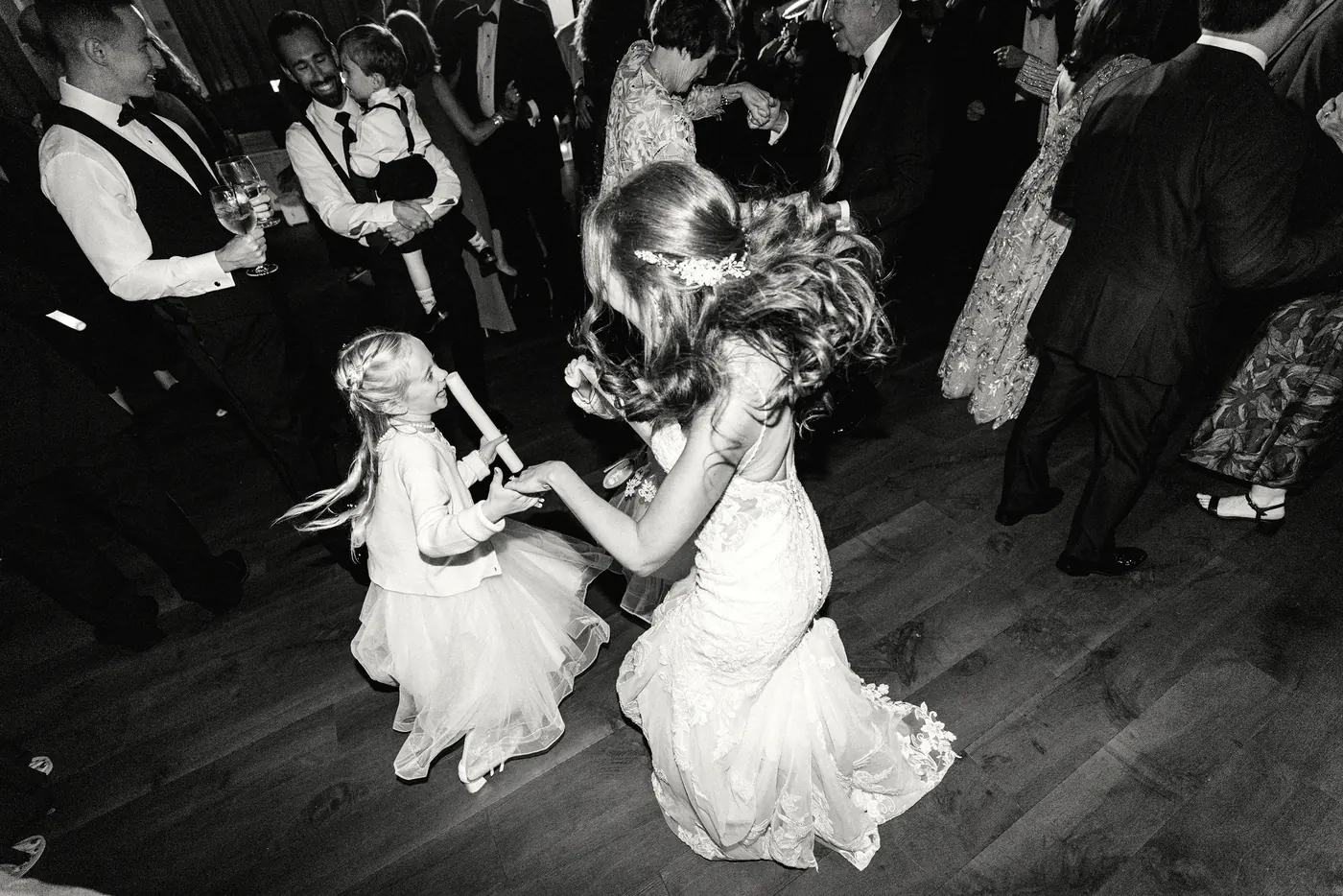 Black and white photo of Danielle dancing with the flower girl at Cescaphe Ballroom at the Ben in Philadelphia
