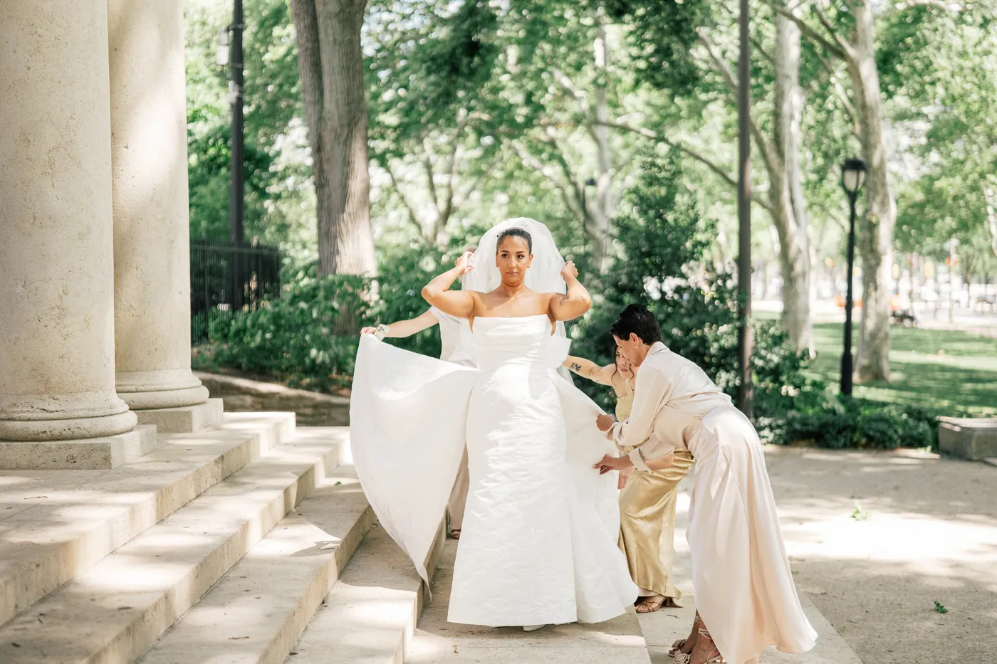 Gianna's mom fluffing her wedding gown on the stone steps of the Rodin Museum in Philadelphia