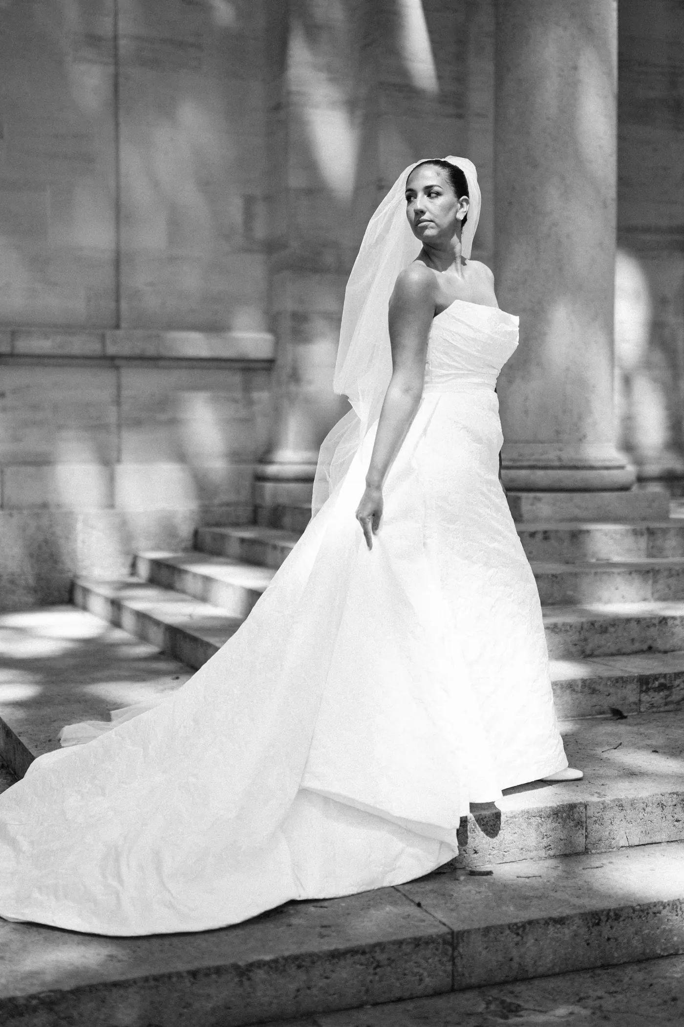 Black and white photo of Gianna looking over her shoulder on the museum steps