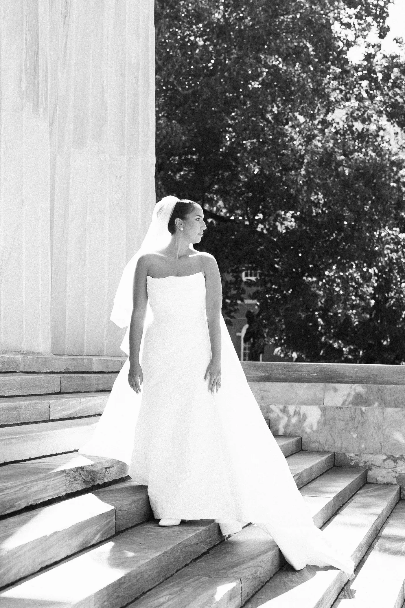 Black and white photo of Gianna on marble steps beside a tall column