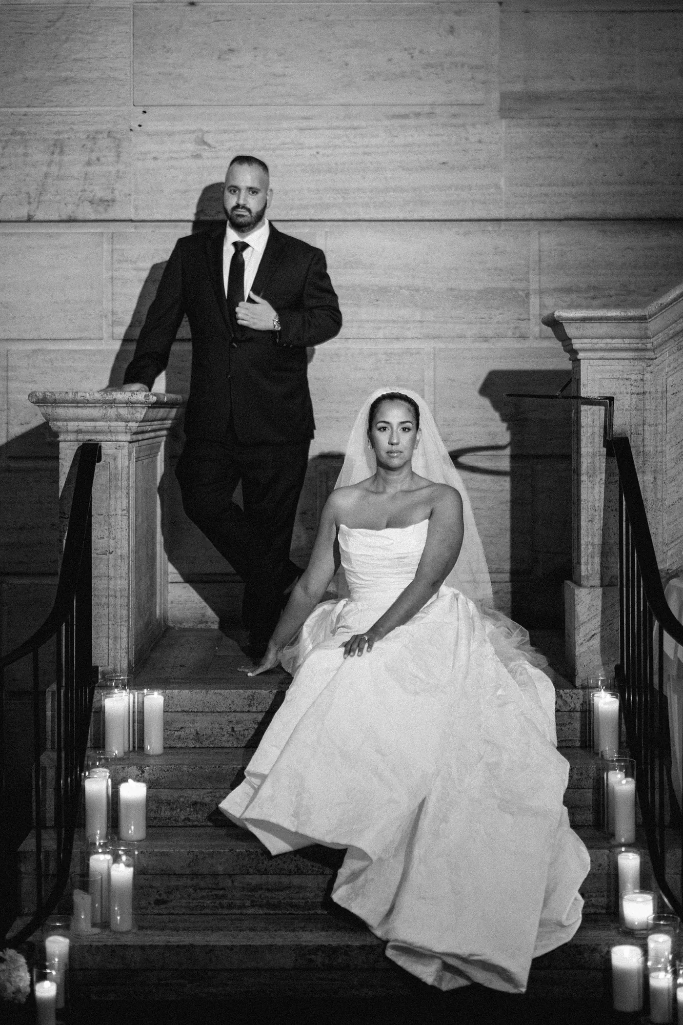 Black and white portrait of Gianna and Simon on the candlelit staircase inside the Union Trust