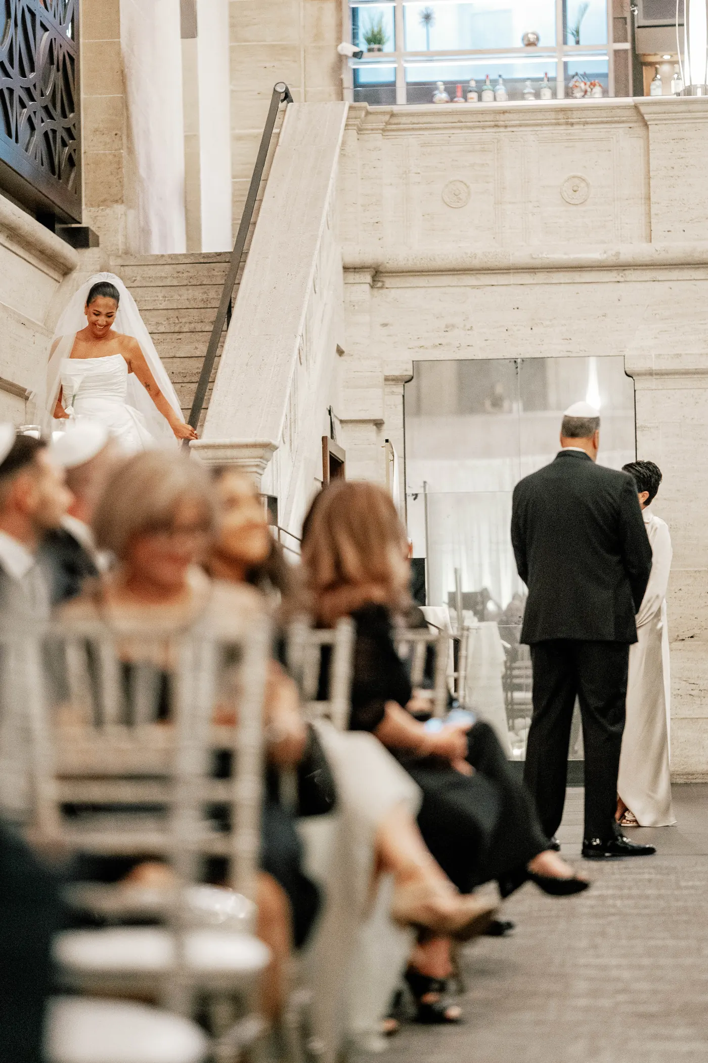 Gianna arriving at the top of the staircase as Simon waits at the front of the ceremony