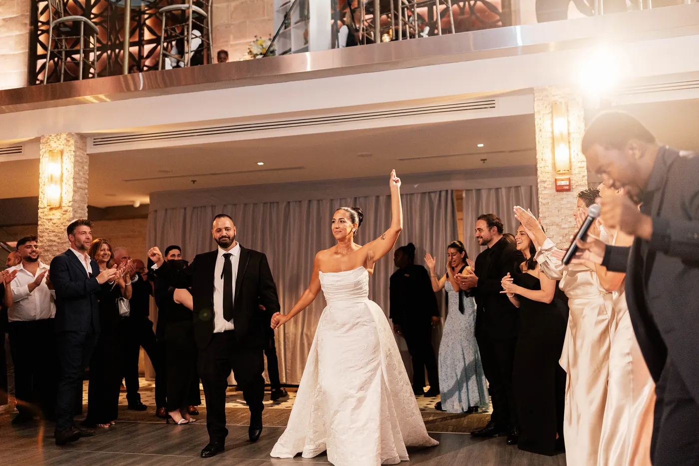 Gianna and Simon dancing into the reception as the MC hypes the crowd