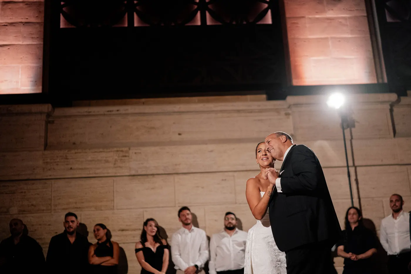 Gianna dancing with her dad as guests look on