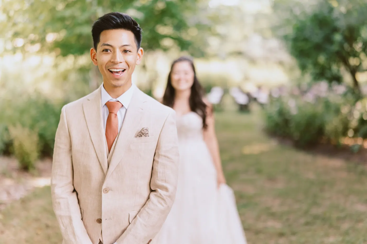 Ivan grinning as Camille walks up behind him for their first look in the garden at Bishop Farmstead