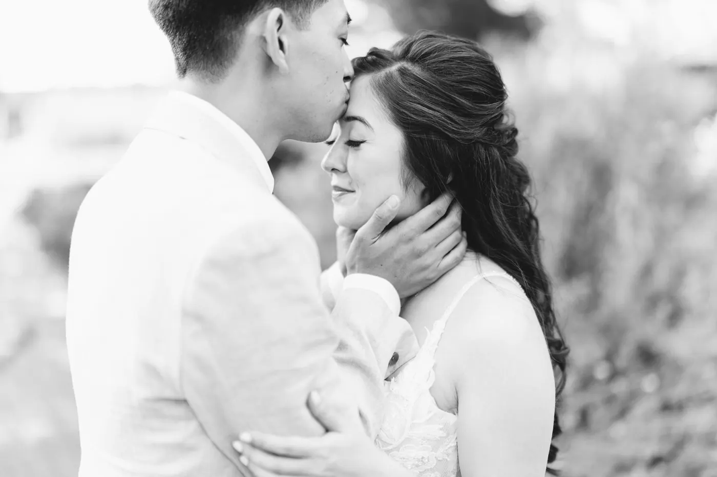 Black and white photo of Ivan kissing Camille's forehead