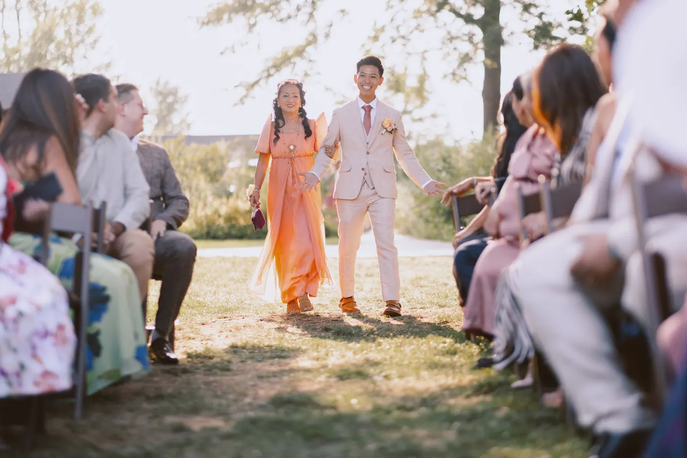 Ivan walking down the aisle with a family member as guests look on