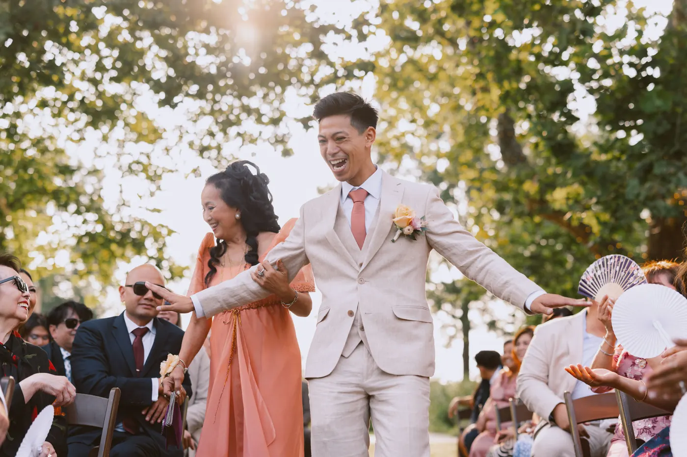 Ivan laughing and reaching out to guests as he walks down the aisle
