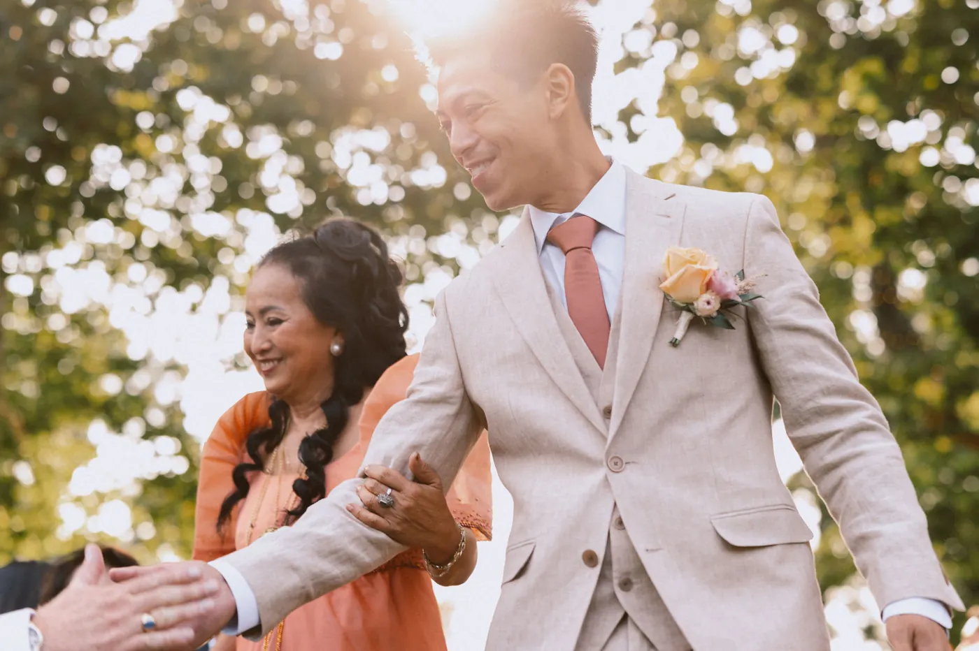 Ivan high-fiving guests on his way down the aisle in the sunlight
