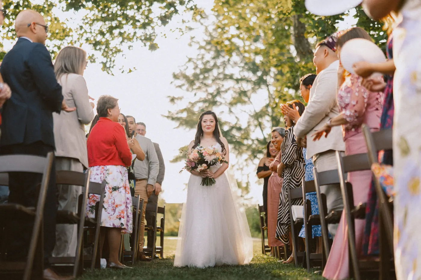 Camille walking down the aisle in the garden ceremony at Bishop Farmstead