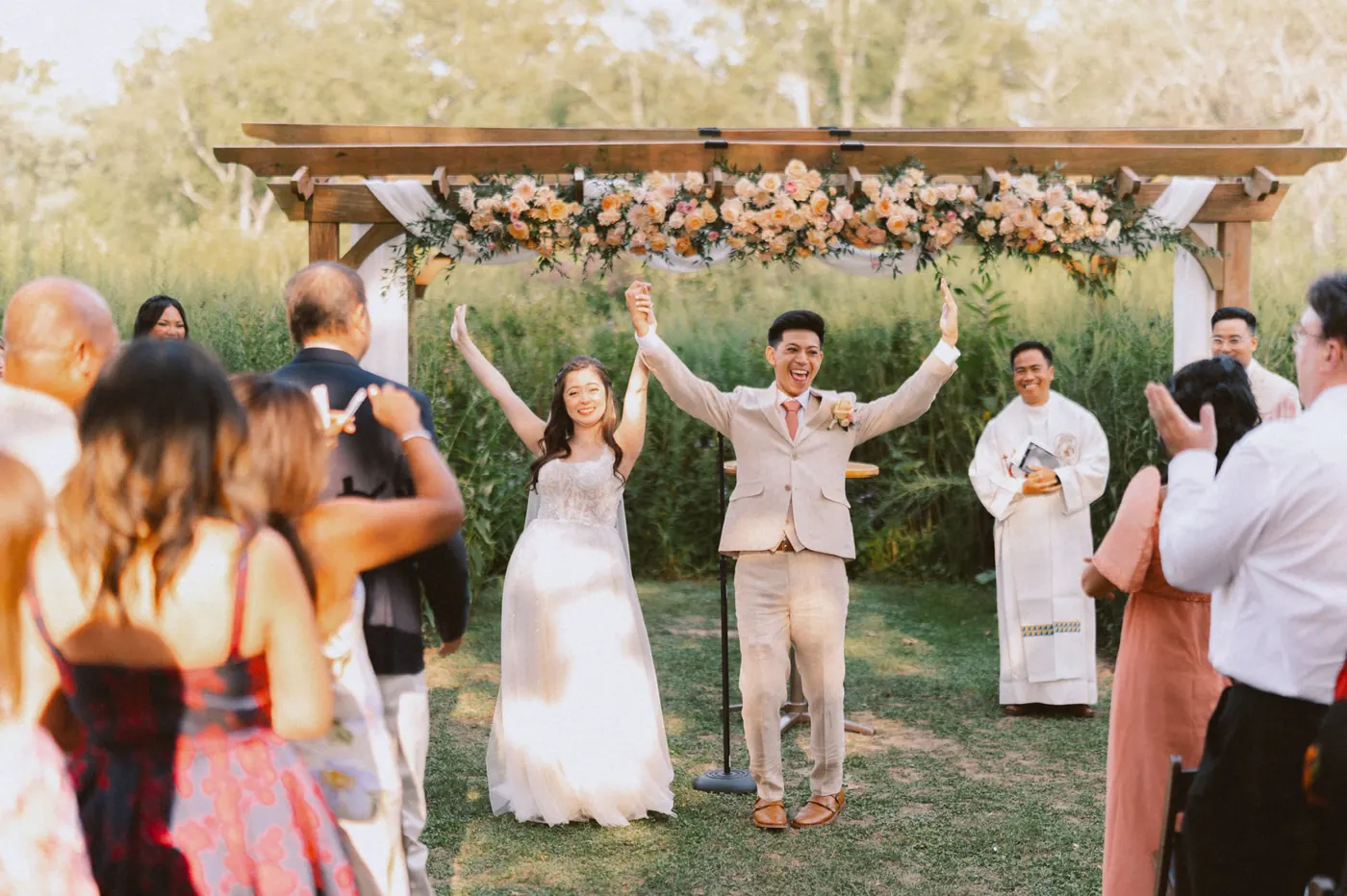 Camille and Ivan raising their arms in celebration as guests cheer