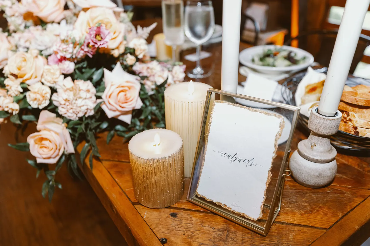Peach roses and candles on the sweetheart table in the barn