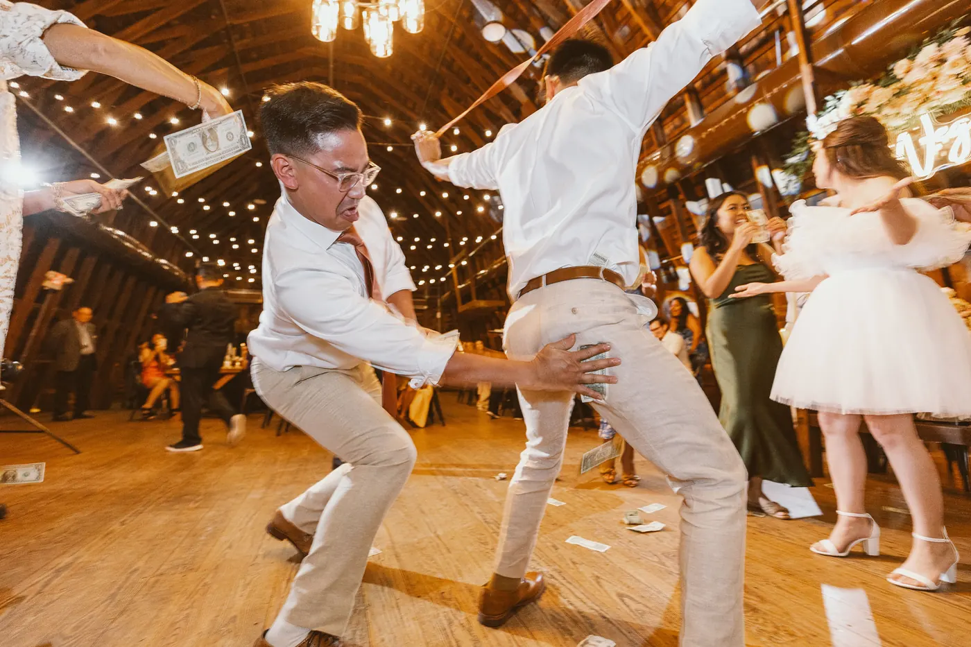 Ivan and a guest dancing as dollar bills fly in the barn