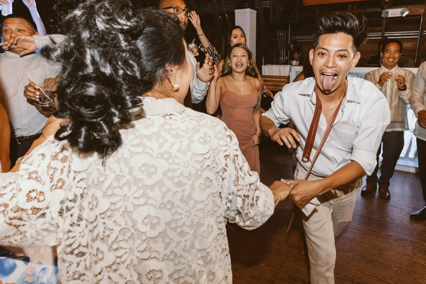 Ivan laughing as he dances with family on the dance floor