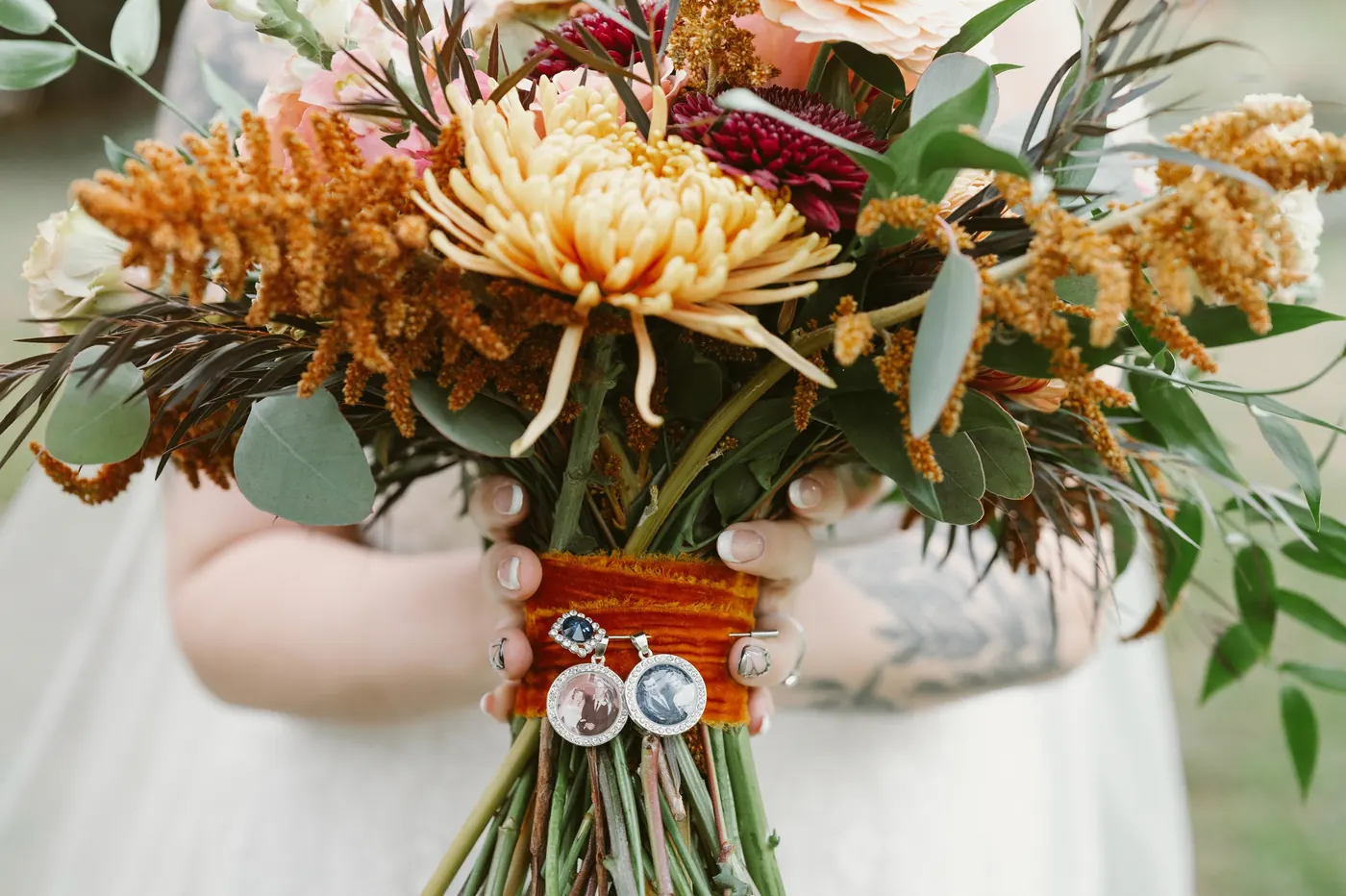 Close-up of Kelsey's autumn bouquet wrapped with memorial photo charms