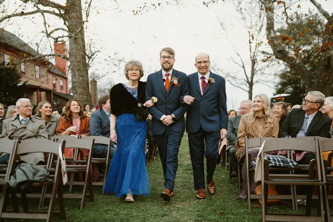 Jimmy walking down the aisle with his parents as guests look on