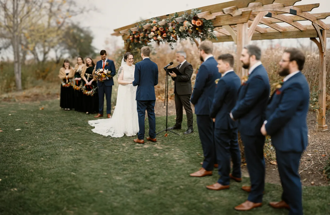 Jimmy and Kelsey's ceremony under the floral pergola with their wedding party