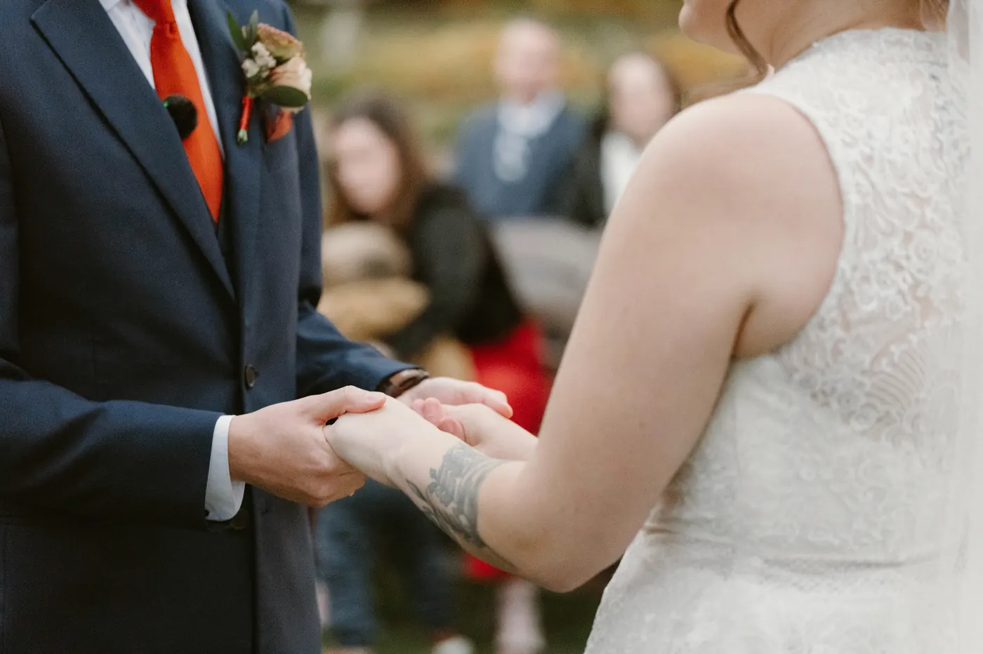 Close-up of Jimmy and Kelsey holding hands during the ceremony