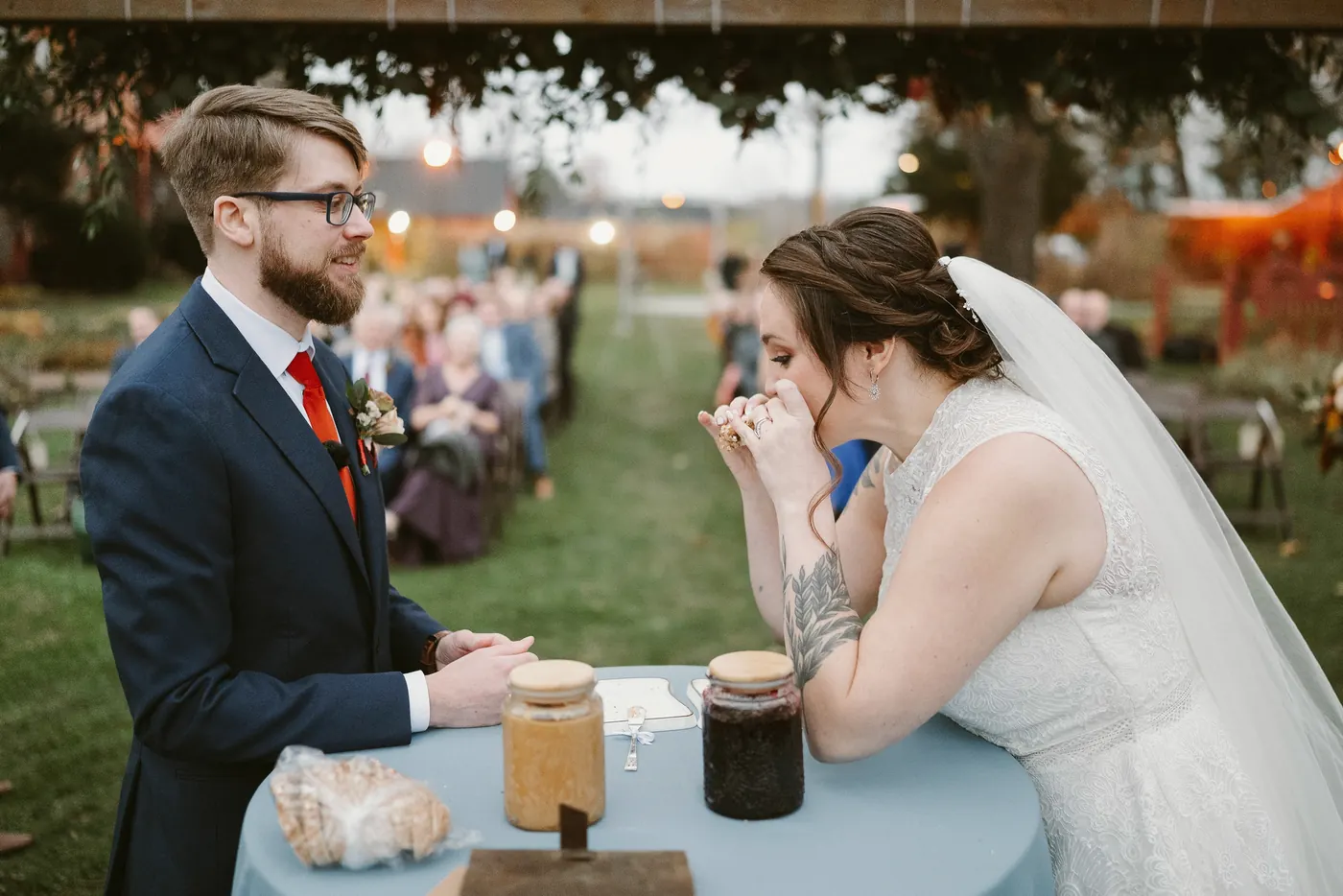 Kelsey laughing as she takes a bite of their peanut butter and jelly sandwich