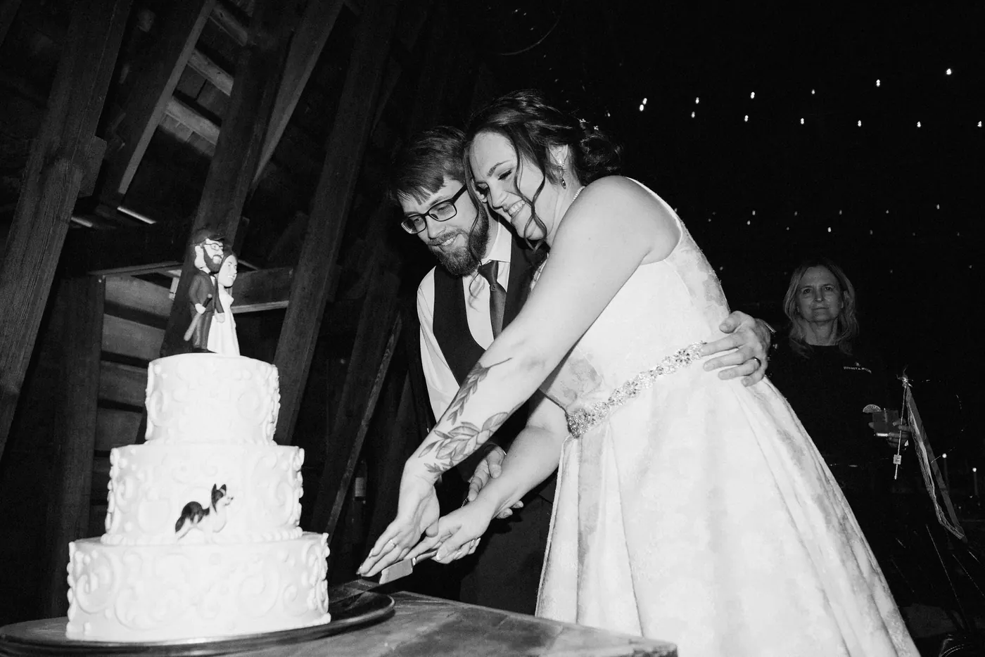 Black and white photo of Jimmy and Kelsey cutting their wedding cake