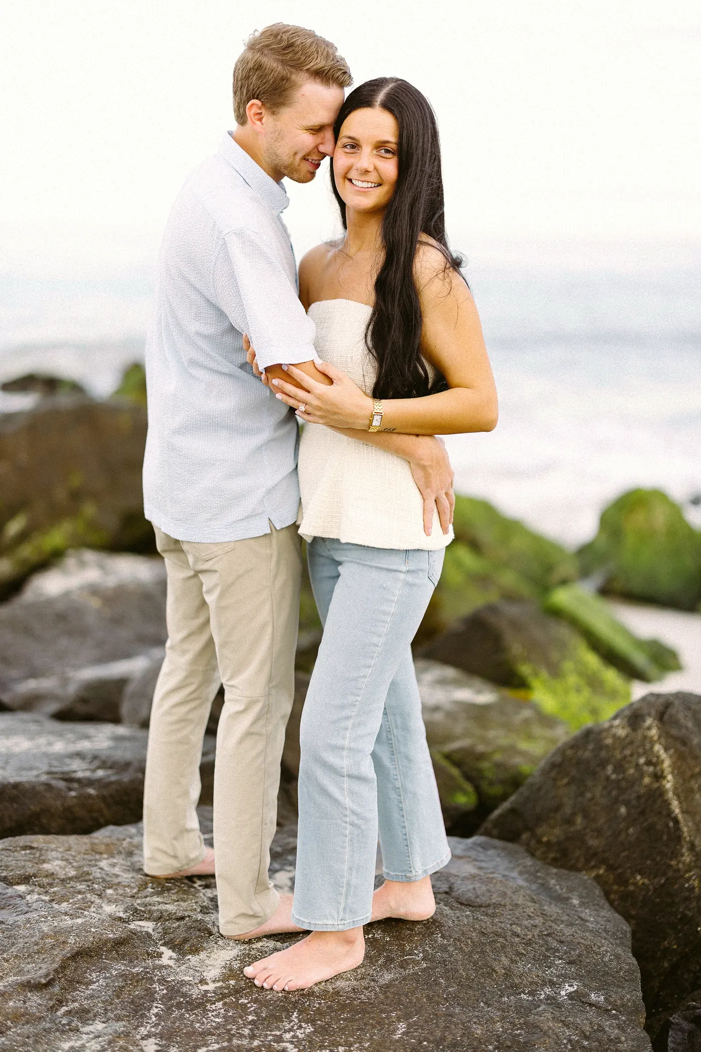 Mason and Morgan embracing on the jetty rocks