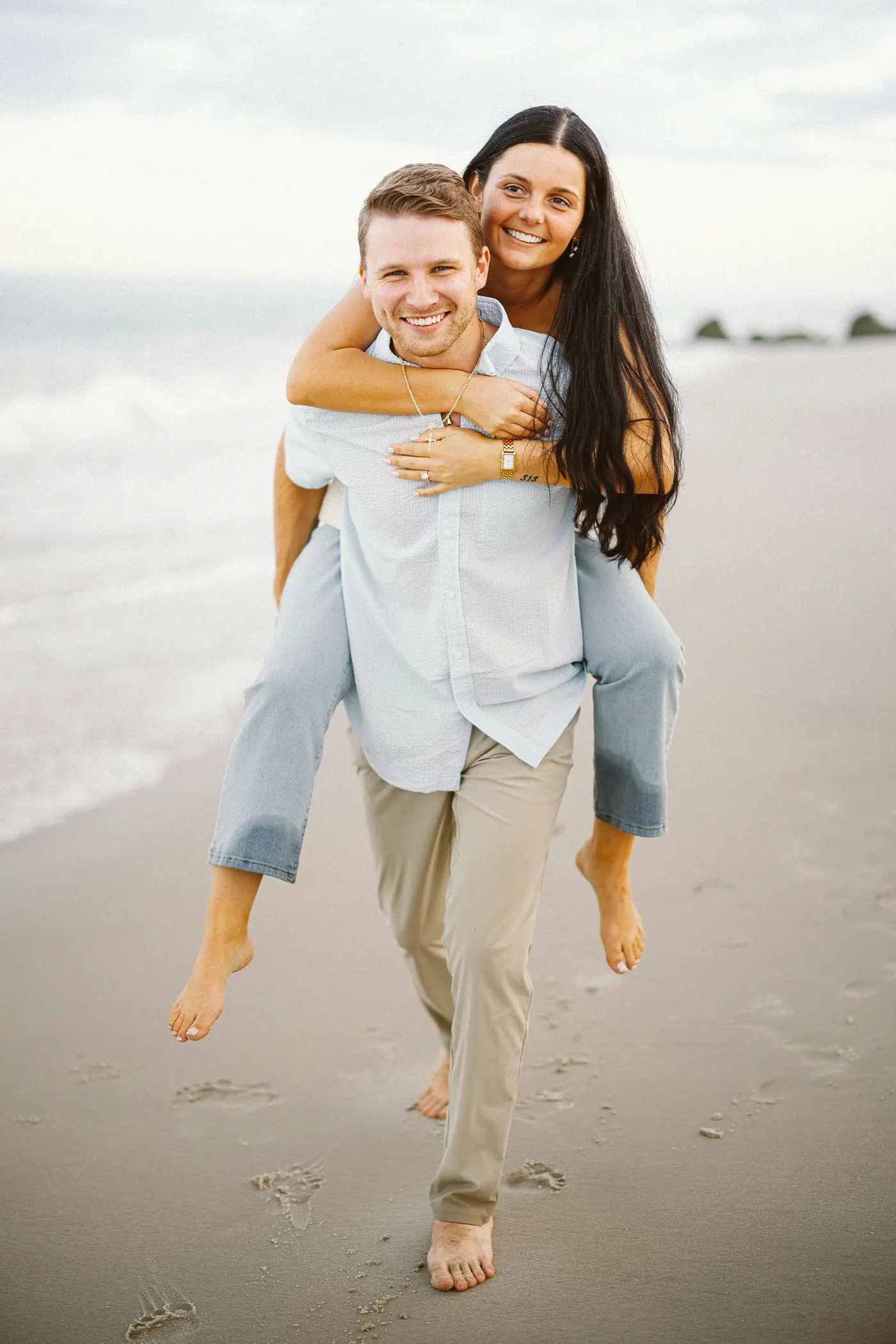 Mason carrying Morgan piggyback across the sand