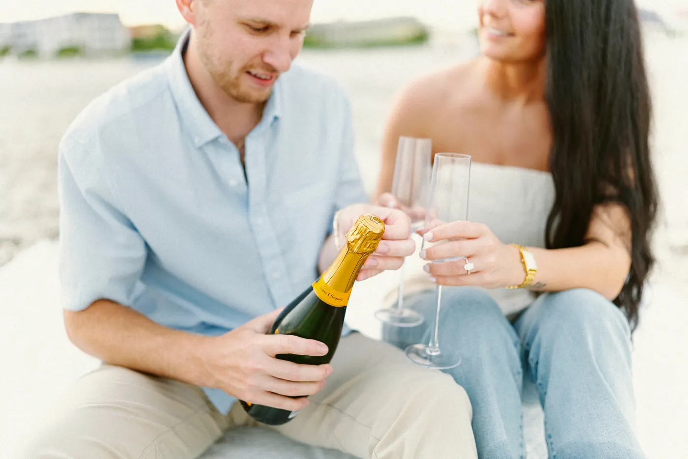 Mason pouring champagne for Morgan on the beach