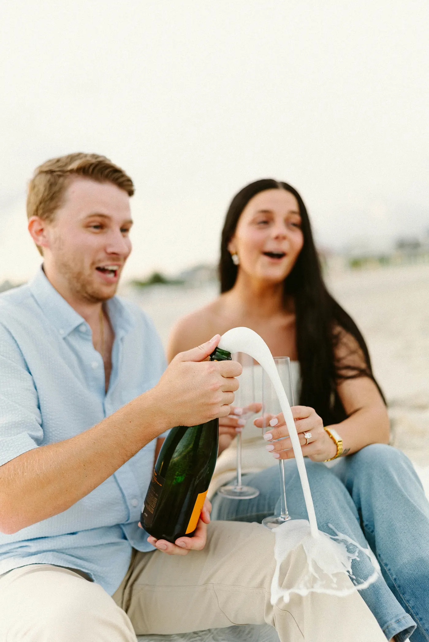 Mason and Morgan popping a bottle of champagne