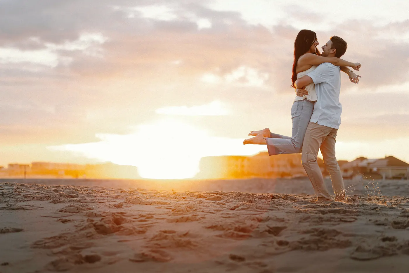 Morgan leaping into Mason's arms at sunset on the beach in Cape May, NJ, near Congress Hall