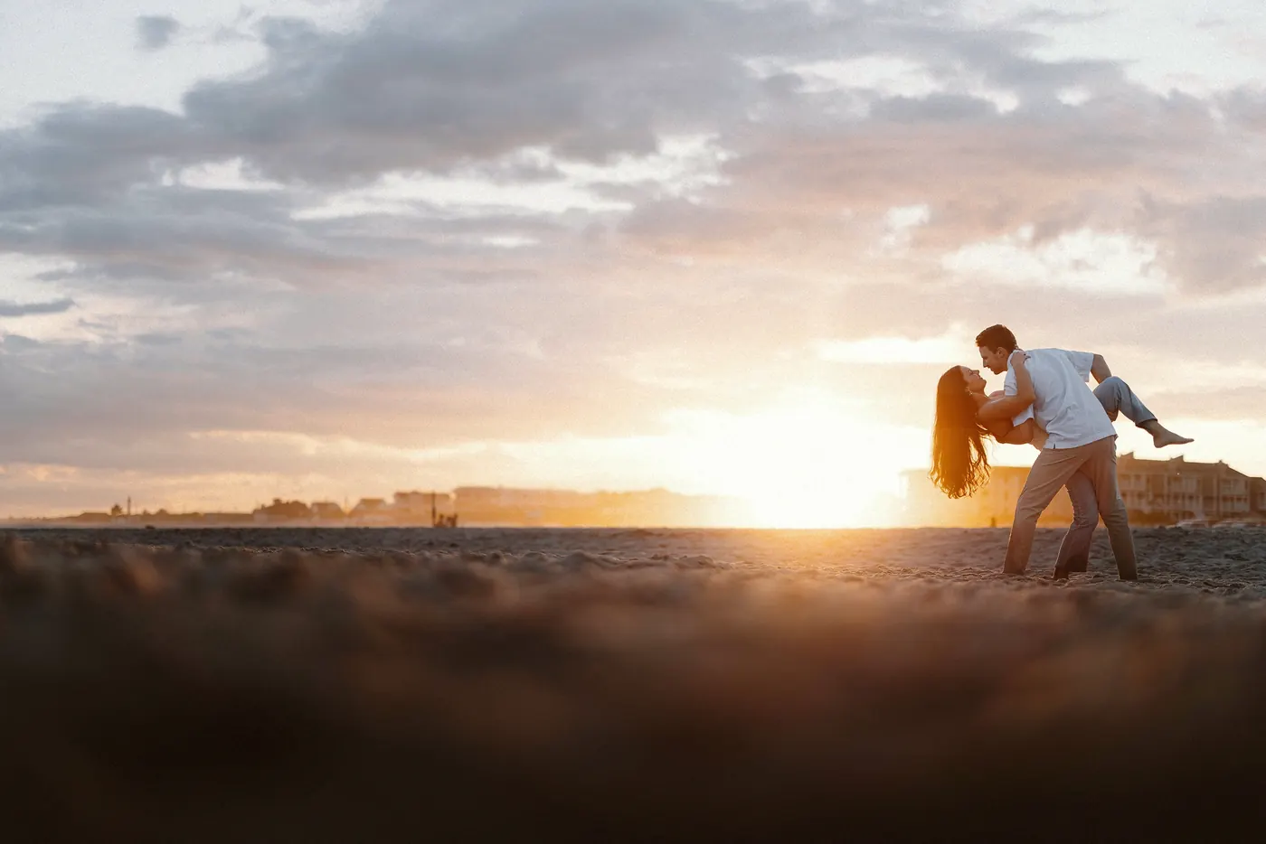Mason dipping Morgan for a kiss on the beach at sunset