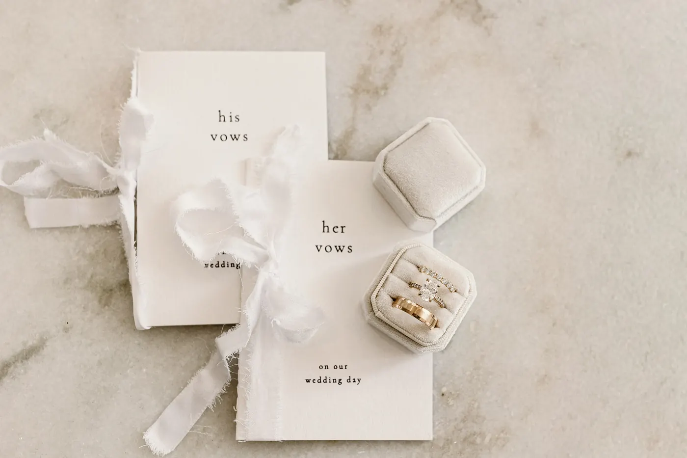 His and her vow books with the wedding rings in a velvet box