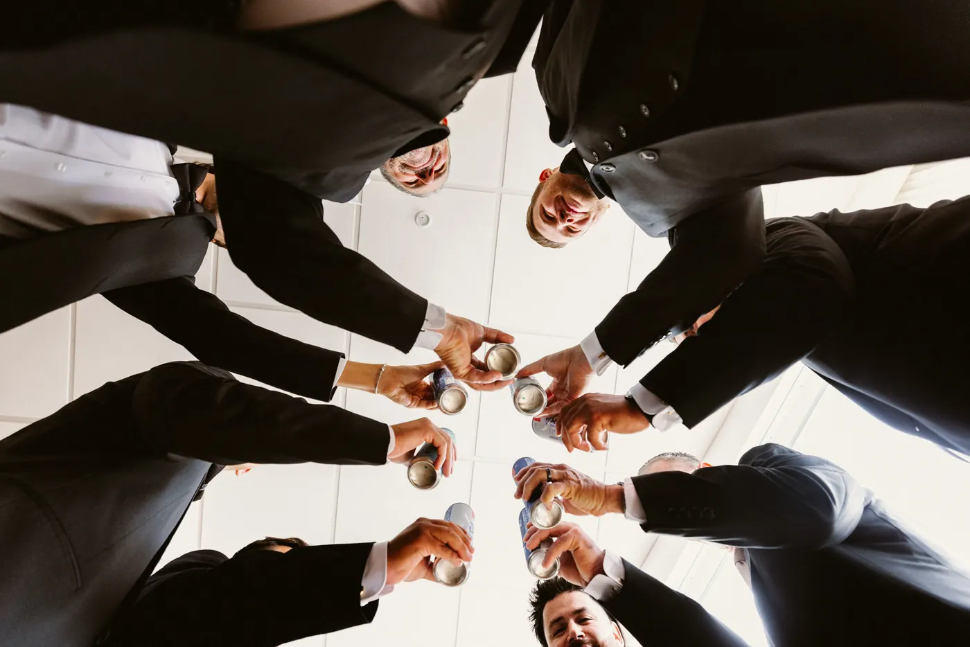 Mason and his groomsmen toasting in a circle, photographed from below