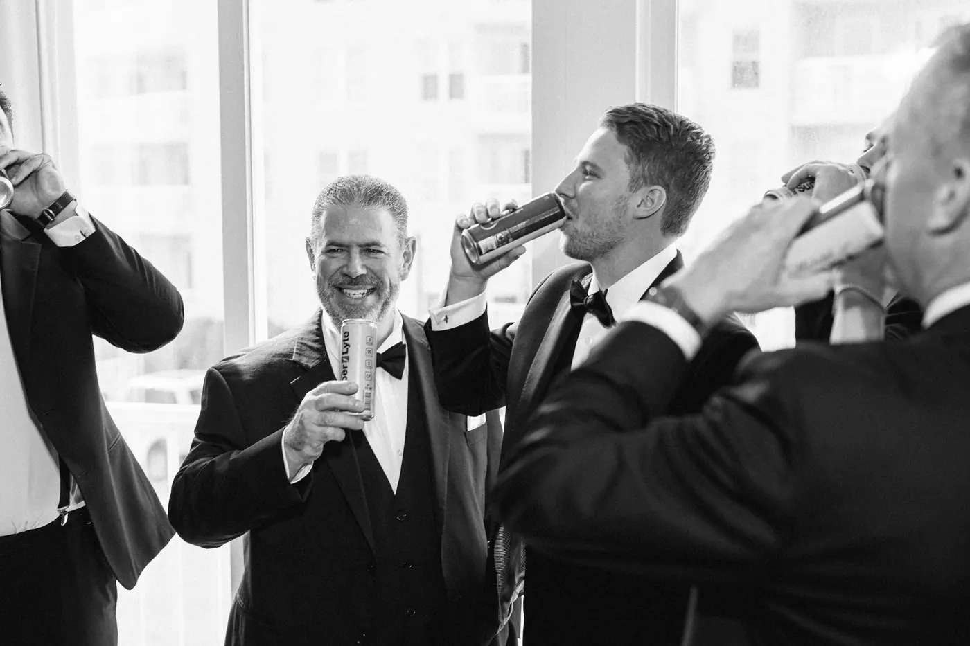 Black and white photo of Mason and his groomsmen sharing a toast before the ceremony