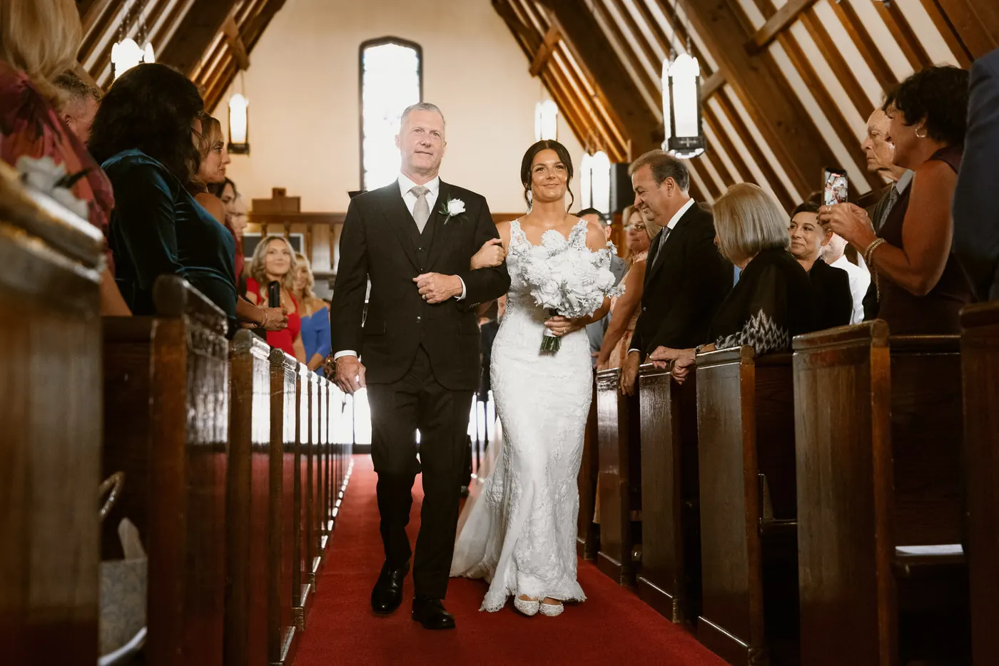 Morgan's dad walking her down the aisle at Sacred Heart Church in Avalon