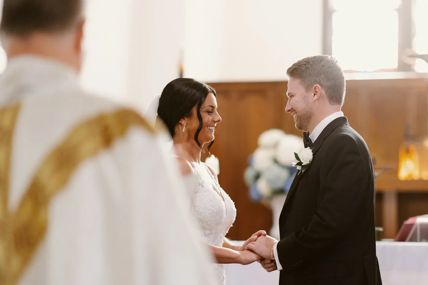Mason and Morgan smiling at each other as they hold hands during their vows